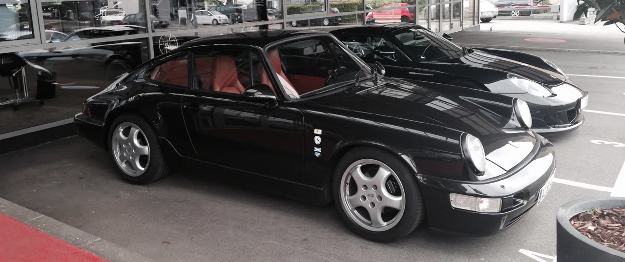 Sort Porsche 964 ved siden af en sort 911 GT, eftersyn efter banekørsel