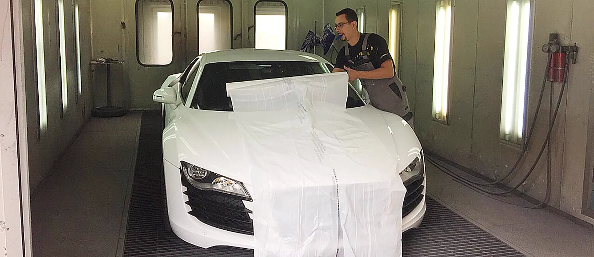 Kire maskerer en hvid Audi R8 inden lakering inde i sprøjtekabinen