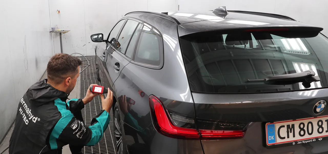 Sergio i Permahyd-Truetac arbejdstøj aflæser originalkoden på en grå BMW Touring med en ColorReader